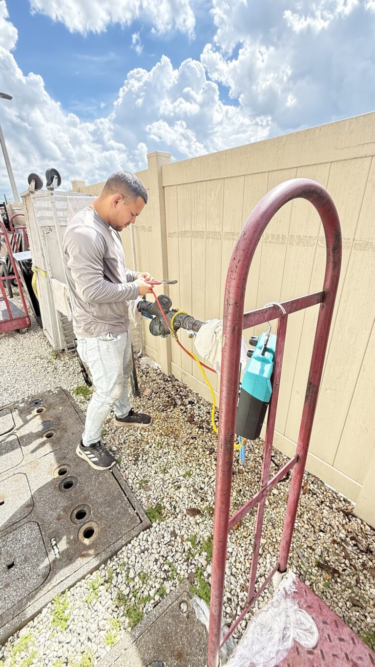 Blessed Solutions Plumbing technician performing a certified backflow preventer test at a commercial property in Orlando FL